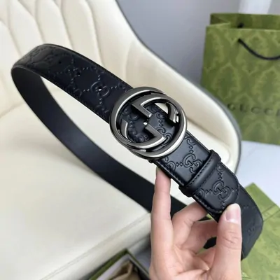 Black belt and metal buckle held in one hand