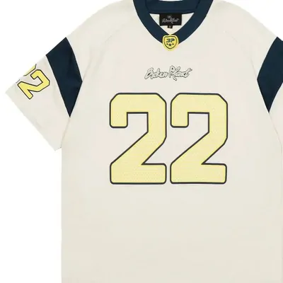 Cream sports jersey with dark shoulder panels and number 22