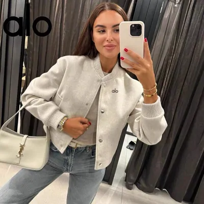 Woman wearing a light jacket in a mirror photograph