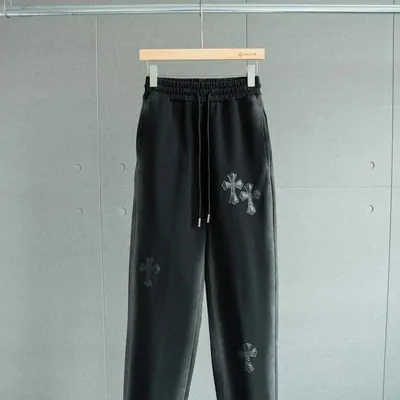 Dark sweatpants hanging against a pale wall